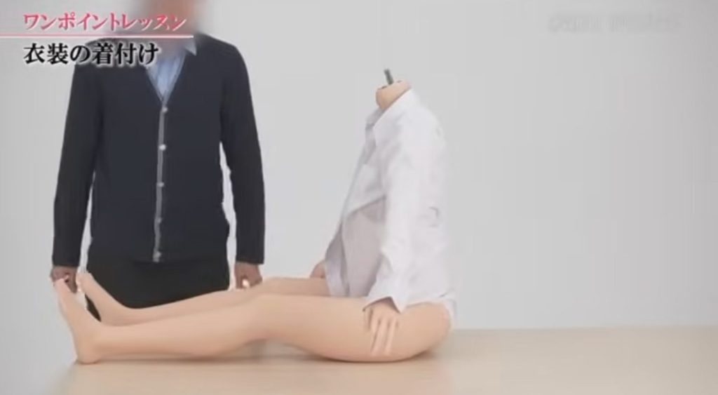 ラブドールの腕を戻し、生地を整える様子